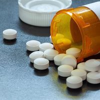Prescription bottle with backlit Oxycodone tablets.
