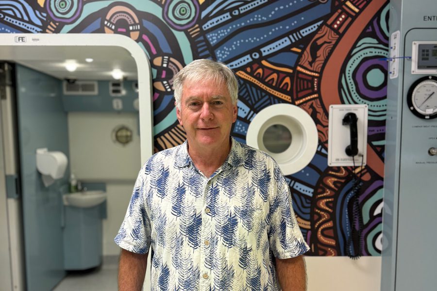 Bob Campbell stands in front of the RBWH hyperbaric chamber