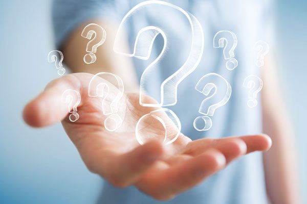 Hand holding hand drawn questions marks - Frequently asked questions