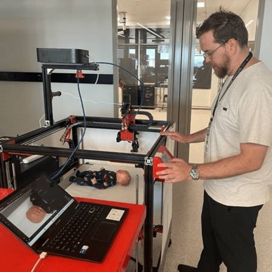 engstudentphotogrammetry male student operating a large 3D printer that has a camera mounted on it as a mock photogrammetry rig