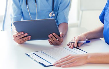 Image of health professionals with iPad and clipboard