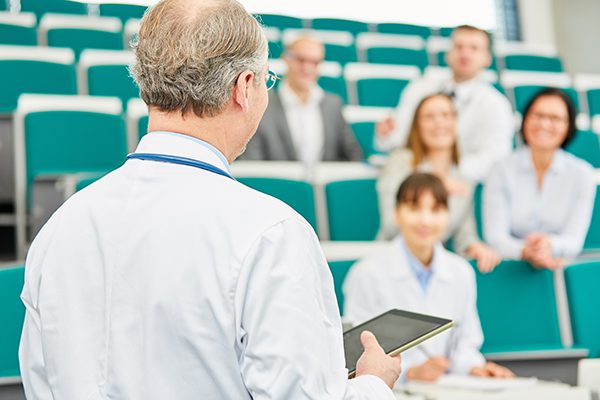 Lecturer teaching doctors in lecture hall