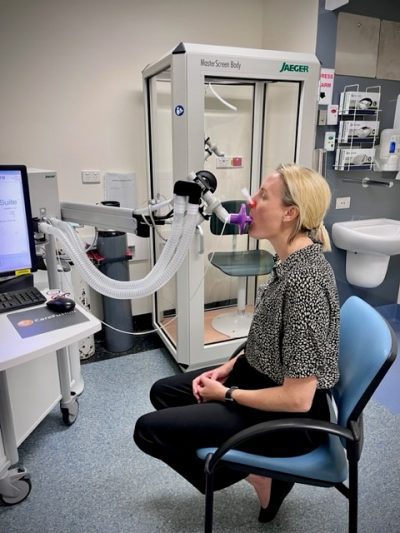 Person blowing into a respiratory function testing machine